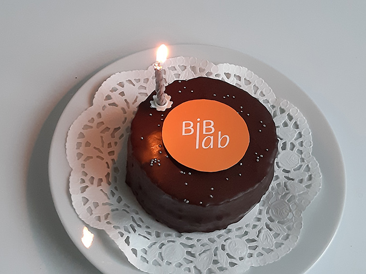 Schokoladentorte mit dem BiB-Lab Logo und einer Geburtstagskerze.