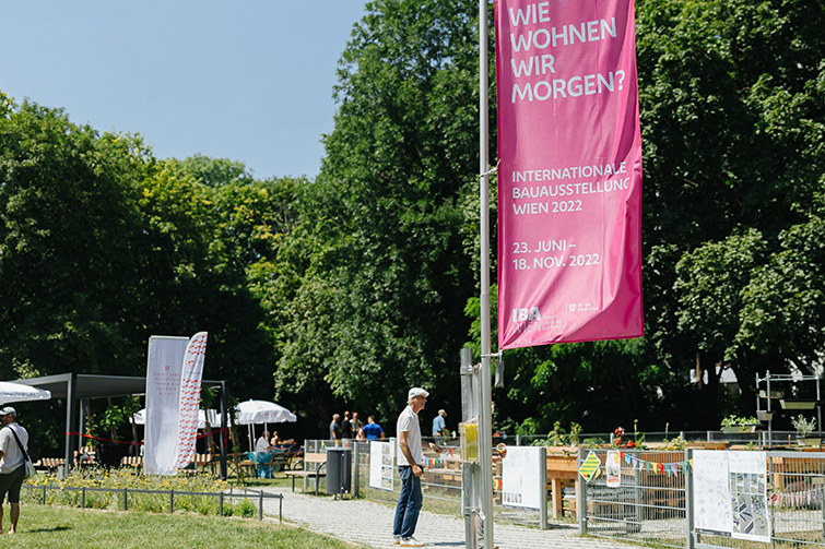 Gemeinschaftsgarten mit Menschen und Bäumen im Hintergrund