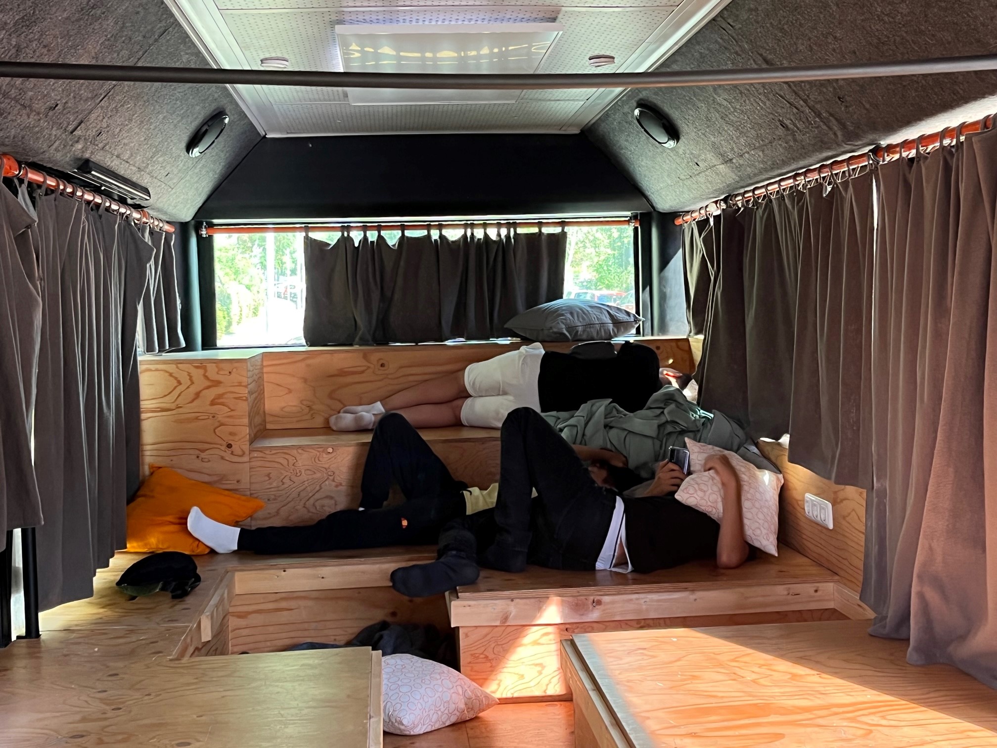 Kinder liegen im hinteren Teil des Bus-Labors, sie verdecken ihre Gesichter bzw sind weggedreht. Sie wollen chillen und ihre Ruhe haben.