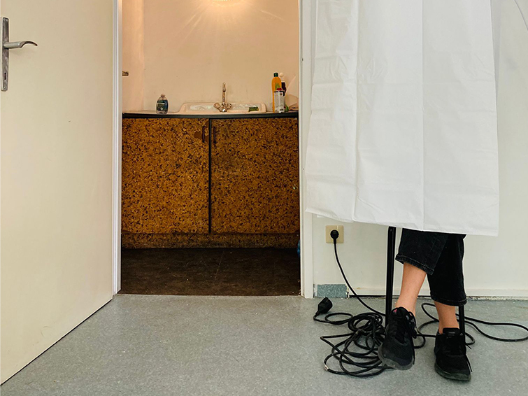 Blick auf Tür, Waschbecken, Kabel und Füsse